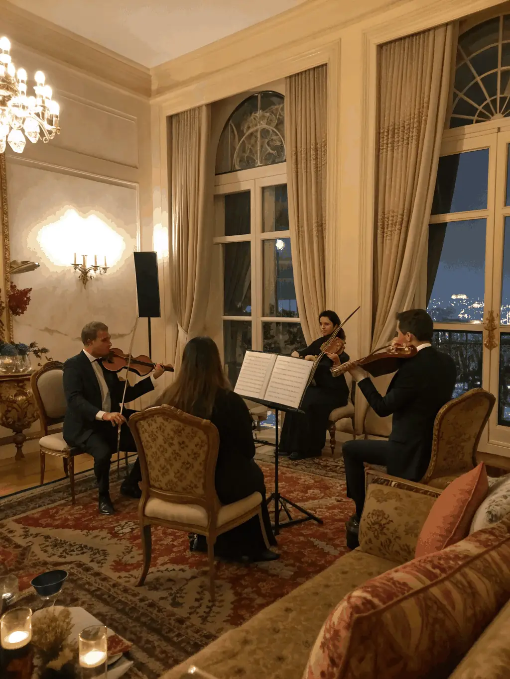 A captivating image of musicians performing at the Music & Movement Gala, featuring a string quartet in formal attire, playing under elegant chandeliers in a grand hall.